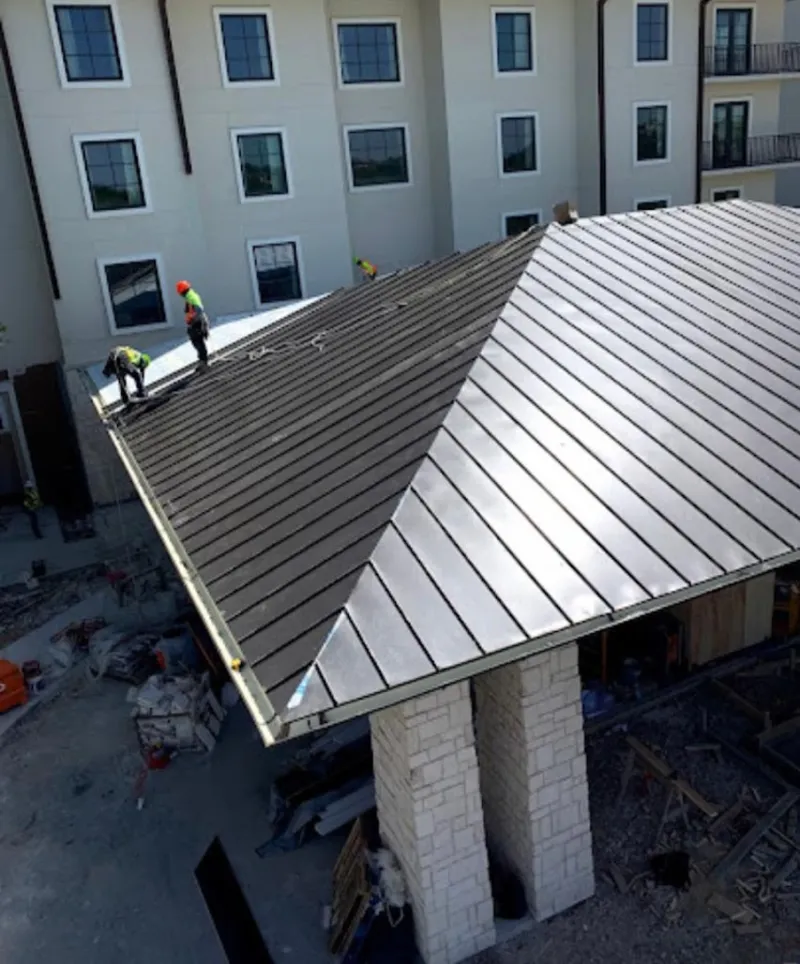 Crew installing standing seam metal roof panels on a commercial project in Sheffield Lake